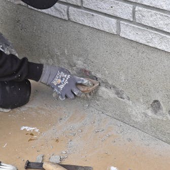 Skader i sokkelpuds: Børst hullerne fri for løse stumper og støv Skader i sokkelpuds: Børst hullerne fri for løse stumper og støv